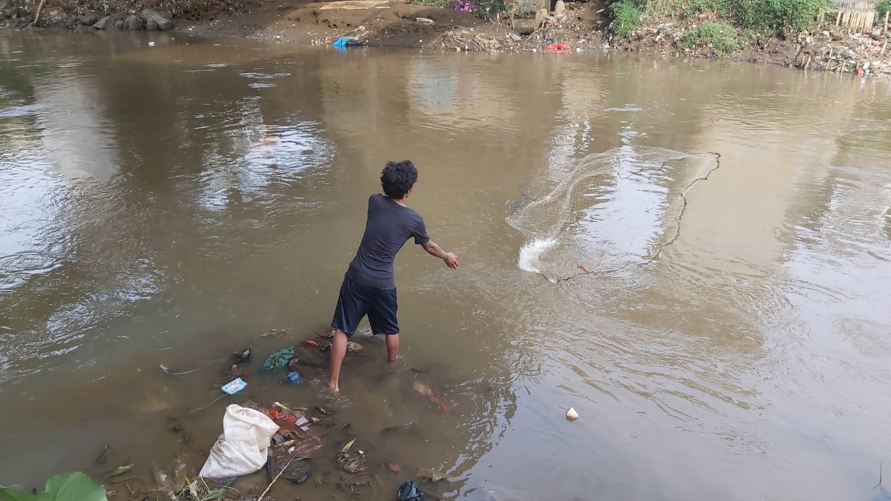 Hasrul Mencari Ikan Sapu-Sapu di Bantaran Sungai Ciliwung